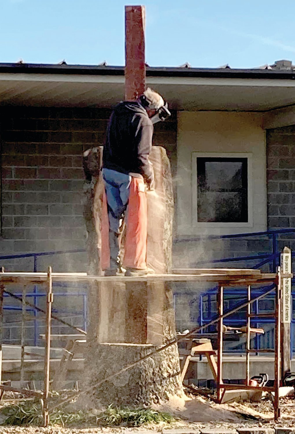 Joe Dudenhoeffer works to transform the tree into a crucifix. The carving was completed on Dec. 5.